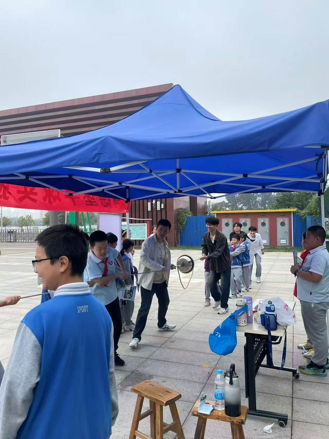 一群人站在蓝色的伞 AI 生成的内容可能不正确。